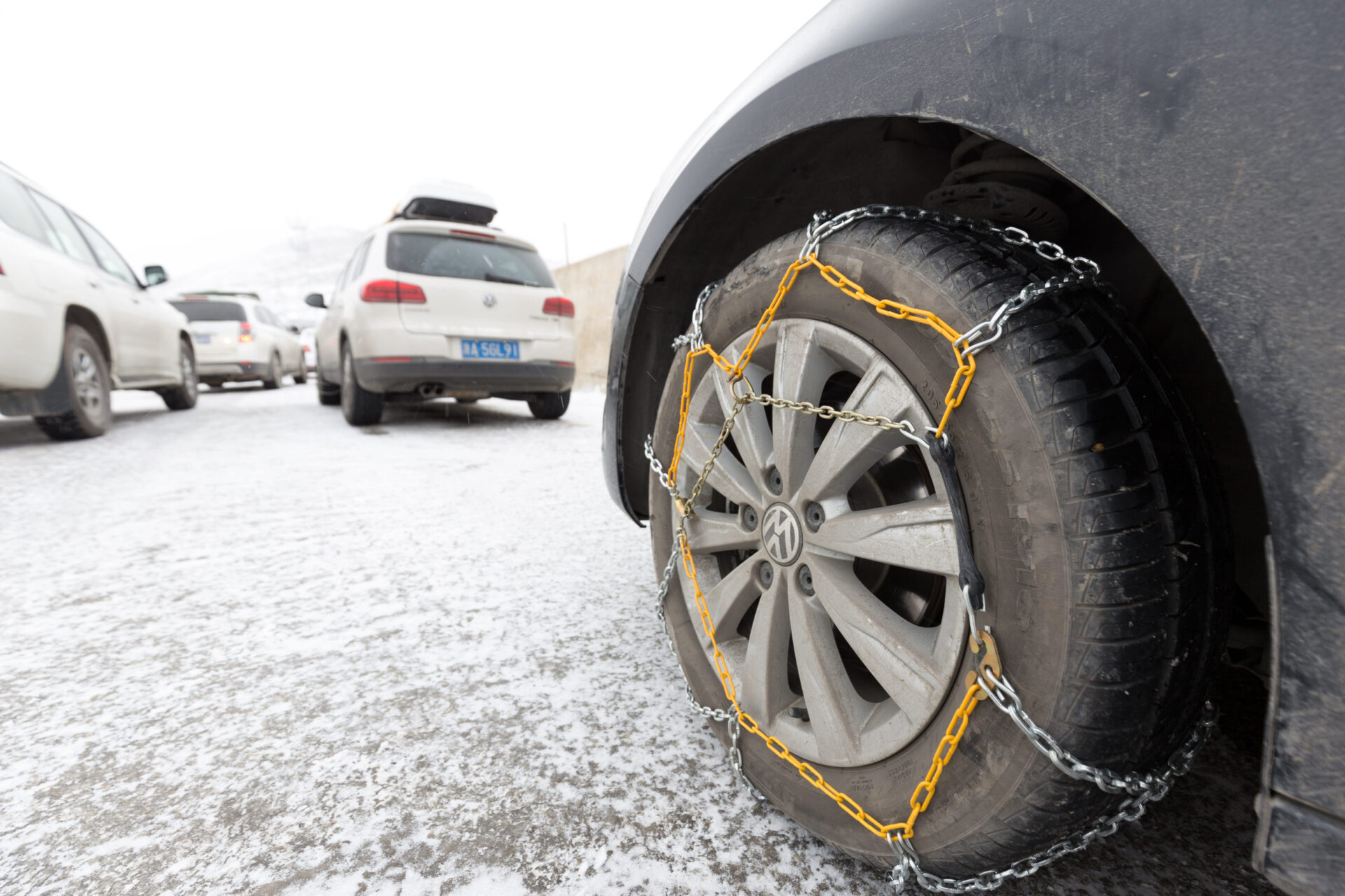 Auto so snehovými reťazami na pneumatikách počas jazdy na zasneženej ceste